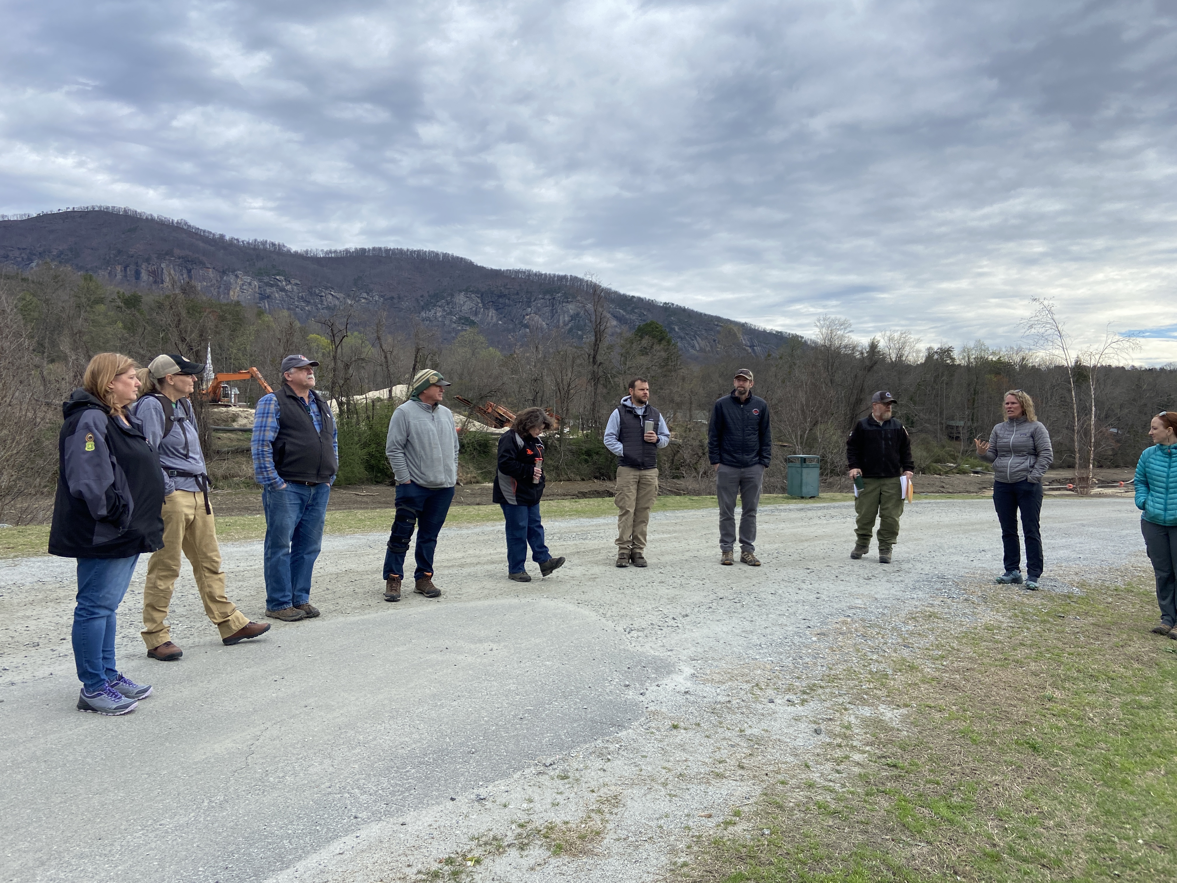 Natural resource professional people standing in a group outdoors with mountains in the background.